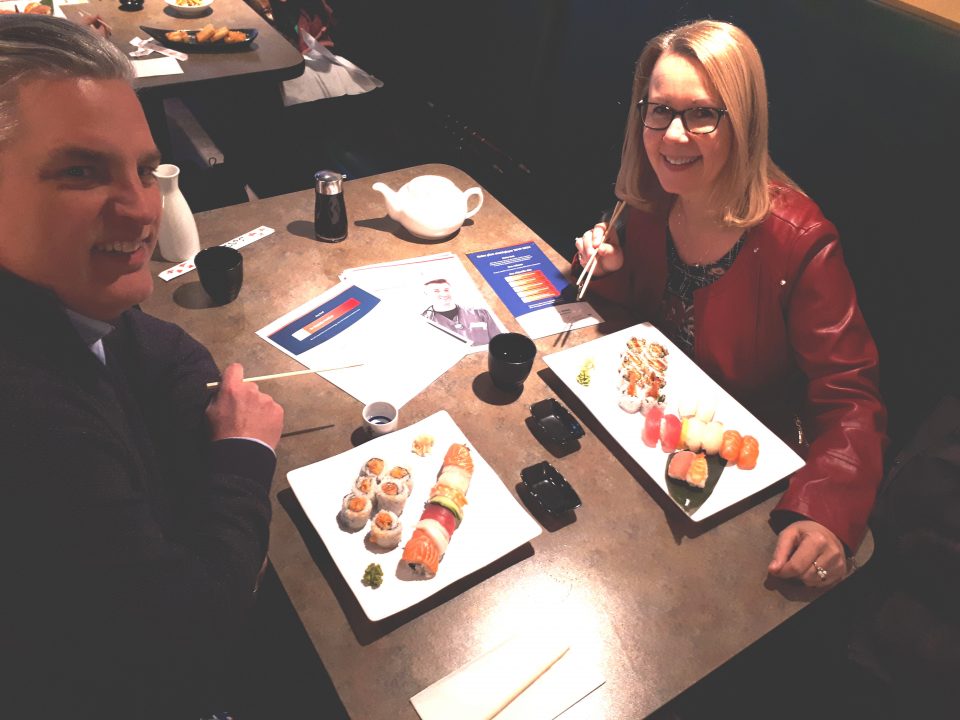 Noel Devost and Anne-Marie Baker Devost eating sushi at a restaurant.